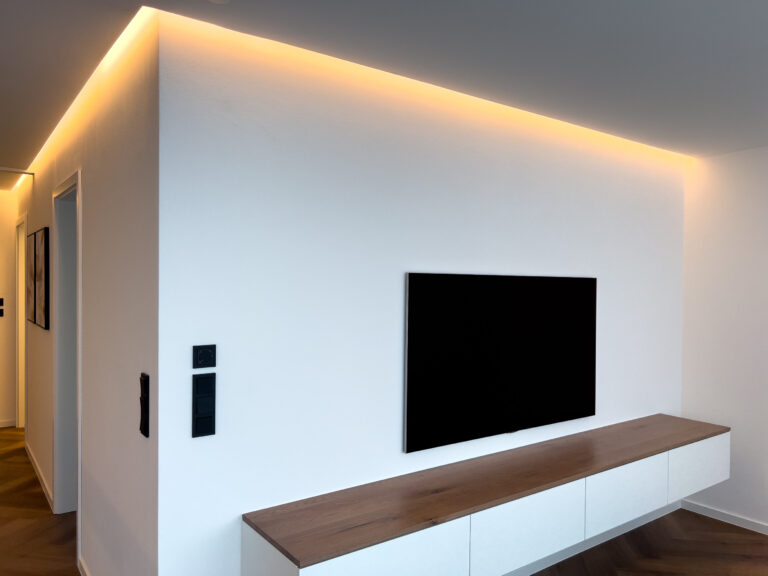 Modernes Wohnzimmer mit indirekter LED-Deckenbeleuchtung in einer Schattenfuge.