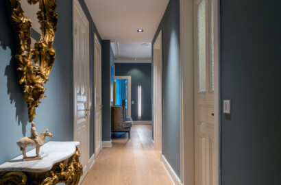 Eleganter Flur mit Einbauspots in abgehängter Decke und ruhiger, gleichmäßiger Grundbeleuchtung