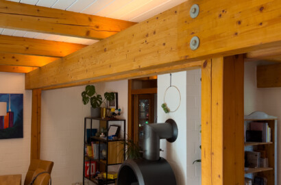Indirekte LED-Beleuchtung an Holzbalken im Ess- und Wohnbereich mit warmer Lichtstimmung