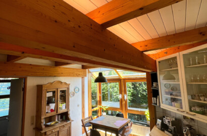 Indirekte LED-Beleuchtung an Holzbalken in offener Küche mit warmer Lichtwirkung