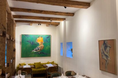 Restaurantinterieur mit sichtbaren Holzbalken, gezielter Wandbeleuchtung und stimmungsvoller Lichtatmosphäre