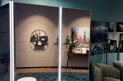 Großformatige Spiegel mit vertikalen LED-Lichtlinien und runden Deckenleuchten in modernem Showroom