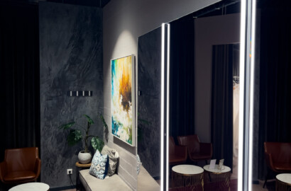 Spiegel mit vertikalen LED-Lichtlinien und runden Deckenleuchten in stilvoll gestaltetem Showroom