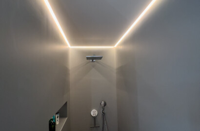 Indirekte LED-Deckenbeleuchtung in der Dusche mit umlaufendem Lichtband im modernen Badezimmer