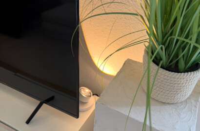 Kompakte Akzentleuchte mit warmem Licht zur dezenten Inszenierung von Pflanzen und Wandflächen im Wohnraum