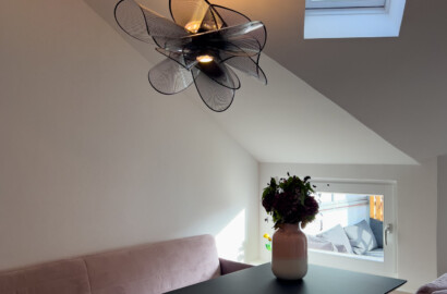 Design-Pendelleuchte mit warmem Licht als skulpturales Highlight über dem Esstisch im Dachgeschoss