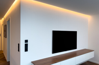 Indirekte LED-Beleuchtung in der Schattenfuge zur ruhigen und wohnlichen Ausleuchtung einer modernen Wohnwand