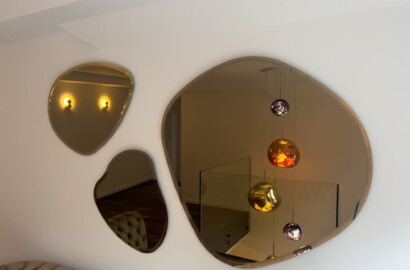 Spiegelbild von Designer-Pendelleuchten und Wandleuchten im Treppenbereich