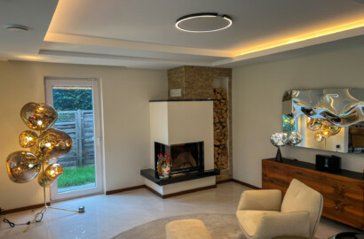 Modernes Wohnzimmer mit Design-Stehleuchte, LED-Deckenlicht und Spiegelreflexion