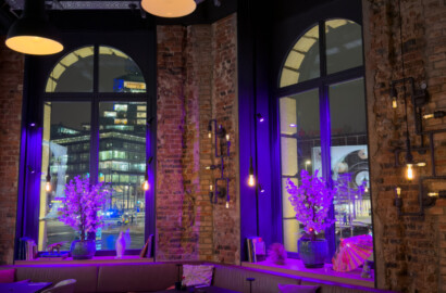 Architektonische Lichtplanung in einem Restaurant mit Pendelleuchten, Akzentbeleuchtung und illuminierten Fensterzonen.